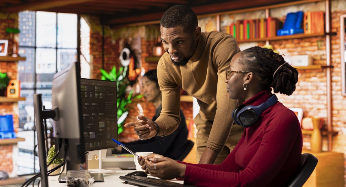 Teamworking startups employees leveraging machine learning technology in office to gain competitive edge. Silicon Valley company colleagues collaborating to do rapid technological advancement